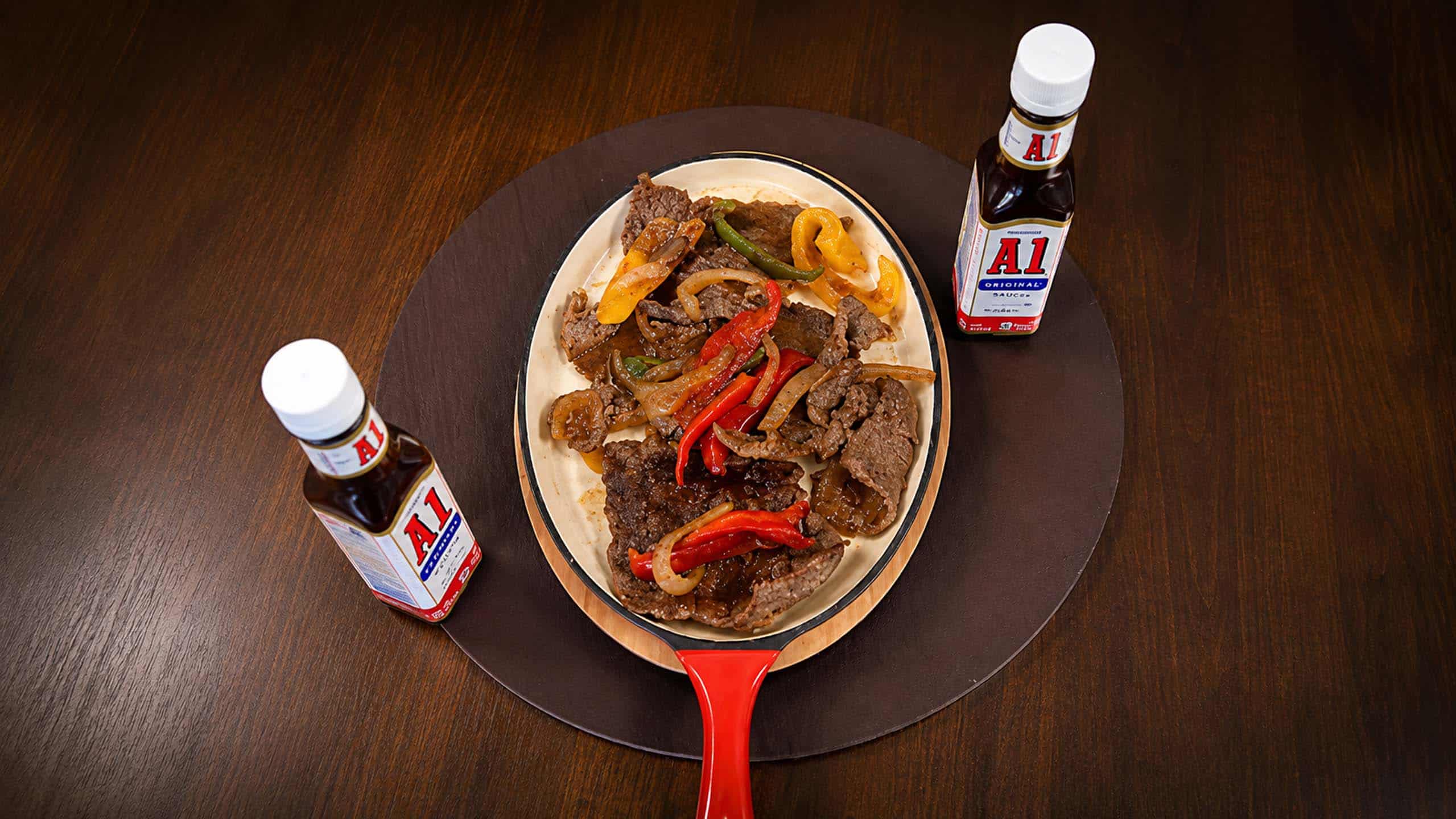 Venezuelan mixed grill with steak and peppers on a sizzling skillet